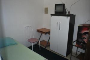 1 dormitorio con 1 cama y TV encima de un armario en Hostel Palmas Centro Da Cidade, en Palmas