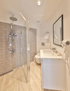 uma casa de banho com um chuveiro, um lavatório e um WC. em Zinbad Hotel Kalkan em Kalkan