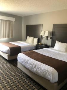 um quarto de hotel com duas camas e duas lâmpadas em Adams Inn and Suites em Adams