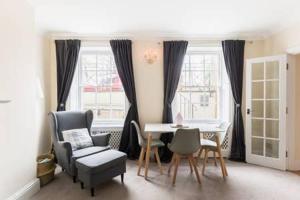 a living room with a table and chairs at Regency apartment - private entrance & courtyard in Cheltenham
