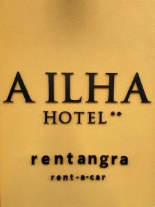 a sign for a hirazi hotel on a wall at Hotel Ilha in Angra do Heroísmo
