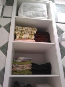 a white shelf with folded blankets and a mattress at Acogedor bungalow muy luminoso in Maspalomas