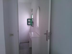 a white bathroom with a sink and a mirror at Acogedor bungalow muy luminoso in Maspalomas