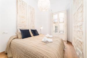een slaapkamer met een groot bed en 2 handdoeken bij Suite Homes Uncibay Square in Málaga