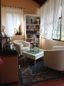 un soggiorno con tavolo, sedie e libreria di B&B Ca' Battista a Montelungo Superiore