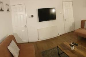sala de estar con sofá y TV en la pared en 6 bed sleeps 10, walk 2 LFC & EFC, Parking,10 mins 2 City, en Liverpool