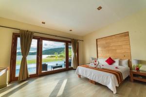 a bedroom with a large bed and a large window at El Sauce Resort in Sauce +79 photos