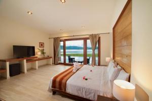 a bedroom with a bed and a large window at El Sauce Resort in Sauce