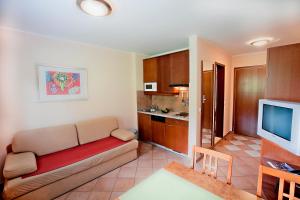 ein Wohnzimmer mit einem Sofa und einer Küche in der Unterkunft Terme Olimia - Aparthotel Rosa in Podčetrtek