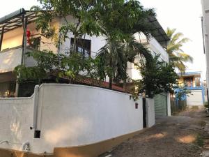a white fence in front of a house at Holiday Home Kotte in Nugegoda