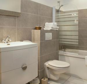 邦多勒的住宿－海灣酒店，浴室配有卫生间、盥洗盆和浴缸。