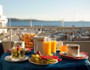 een tafel met eten en sinaasappelsap en fruit bij Hotel de la Baie in Bandol