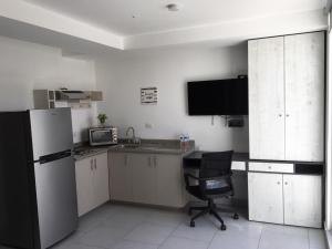 Il comprend une cuisine équipée d'un réfrigérateur et d'une chaise. dans l'établissement Suites André Confort Ejecutivo, à Aguascalientes