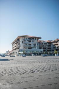 un gran edificio en medio de un estacionamiento en Résidence Néméa l'Estacade, en Capbreton