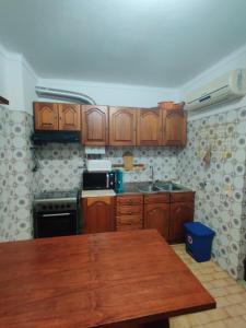 a kitchen with wooden cabinets and a wooden table at Apartamento Vargas in Monte Gordo