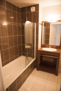 a bathroom with a tub and a sink and a shower at Résidence Néméa l'Estacade in Capbreton