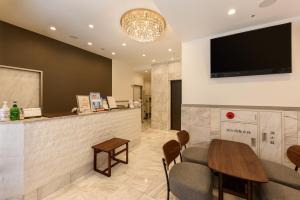 a waiting room with a table and a flat screen tv at Shinbashi Urban Hotel in Tokyo