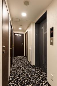 a corridor of a hotel hallway with a carpeted floor at Shinbashi Urban Hotel in Tokyo