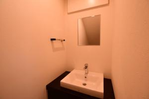 a white sink in a bathroom with a mirror at Koyasan Shukubo Saizenin in Koyasan