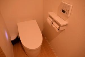 a bathroom with a white toilet and a clock on the wall at Koyasan Shukubo Saizenin in Koyasan