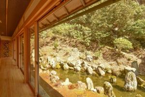 a room with a view of a river with rocks at Koyasan Shukubo Saizenin in Koyasan