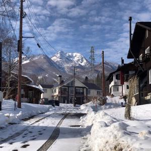 a snow covered street with a mountain in the background at Legend Inn Myoko in Myoko