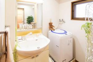 une salle de bain avec un lavabo et une machine à laver dans l'établissement HARMONIA東京堀切 10名定員90平米の広いCondominium, à Tokyo