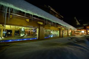 een gebouw met veel ramen 's nachts bij Hotel Sant'Orso - Mountain Lodge & Spa in Cogne