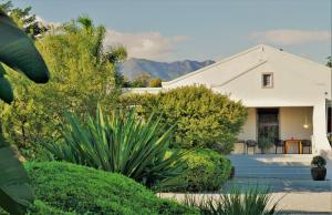 a white house with mountains in the background at Swellendam Country Lodge - Guest House - B&B in Swellendam