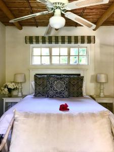 a bedroom with a bed with a red rose on it at Little Willow Brooke in Franschhoek