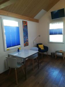 a dining room with a table and chairs and two windows at Montanara in Meiringen