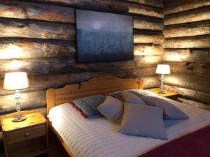 sypialnia z drewnianą ścianą z łóżkiem i telewizorem z płaskim ekranem w obiekcie Avatar Kelo Cottage w mieście Ruka