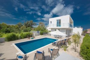 a villa with a swimming pool and a house at Polymnia Luxury Villas in Protaras