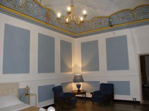 um quarto com um tecto com um candelabro e 2 cadeiras em Il Gattopardo House em Catânia