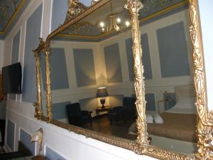 un gran espejo de oro en la pared de una sala de estar en Il Gattopardo House, en Catania