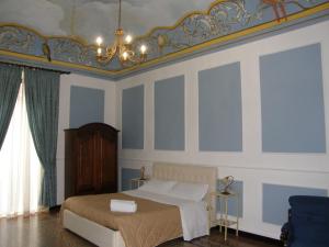1 dormitorio con cama y lámpara de araña en Il Gattopardo House, en Catania