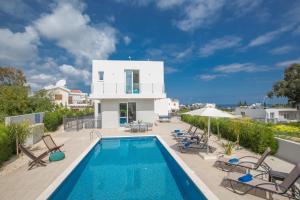 a villa with a swimming pool and a house at Polymnia Luxury Villas in Protaras
