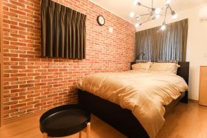 船橋的住宿－Chiba LEO Yonju-Yonbankan #MLx，一间卧室设有砖墙和一张床