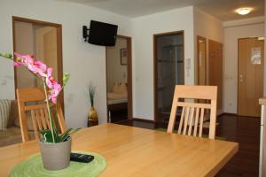 una mesa de comedor con un jarrón de flores. en Alpenjuwel Appartements en Flachau