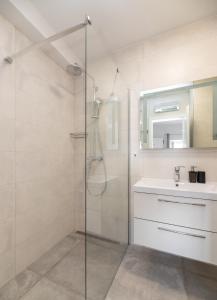 W łazience znajduje się szklana kabina prysznicowa i umywalka. w obiekcie Apinelo w mieście Supetar
