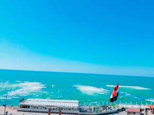 a view of the ocean from a beach with a flag at Royal Crown Hotel عائلات فقط in Alexandria