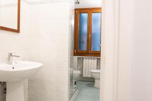 La salle de bains est pourvue d'un lavabo et de toilettes. dans l'établissement The Heart of San Marco - WiFi, à Venise
