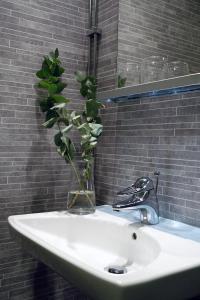 a bathroom sink with a vase with a plant in it at Högbo Hotell Skommarsgården in Sandviken