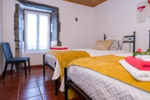 sypialnia z 2 łóżkami i oknem w obiekcie Casa da Agua Quente - AL w mieście Furnas