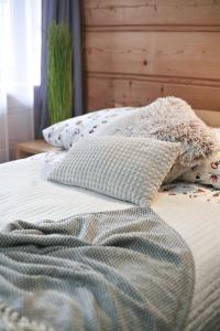 a bed with a blanket and pillows on it at Willa Przy Skoczni in Zakopane
