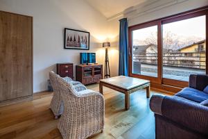 uma sala de estar com um sofá, uma mesa e uma janela em Marina Walensee Hotel em Unterterzen