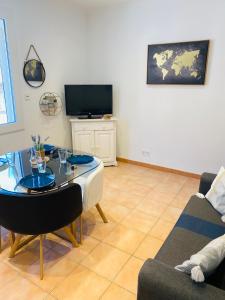 sala de estar con mesa y TV en Appartement F2 30m2, 300m des Thermes, en Lamalou-les-Bains
