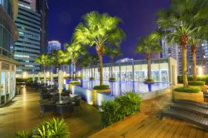 a resort with palm trees and a pool at night at Luxe Suites at Vortex KLCC in Kuala Lumpur