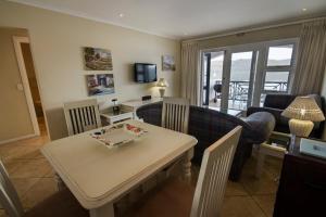 a kitchen and living room with a table and chairs at Laguna Grove 48 in Knysna