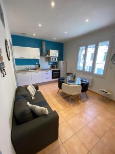 salon i kuchnia z kanapą i stołem w obiekcie Appartement F2 30m2, 300m des Thermes w mieście Lamalou-les-Bains
